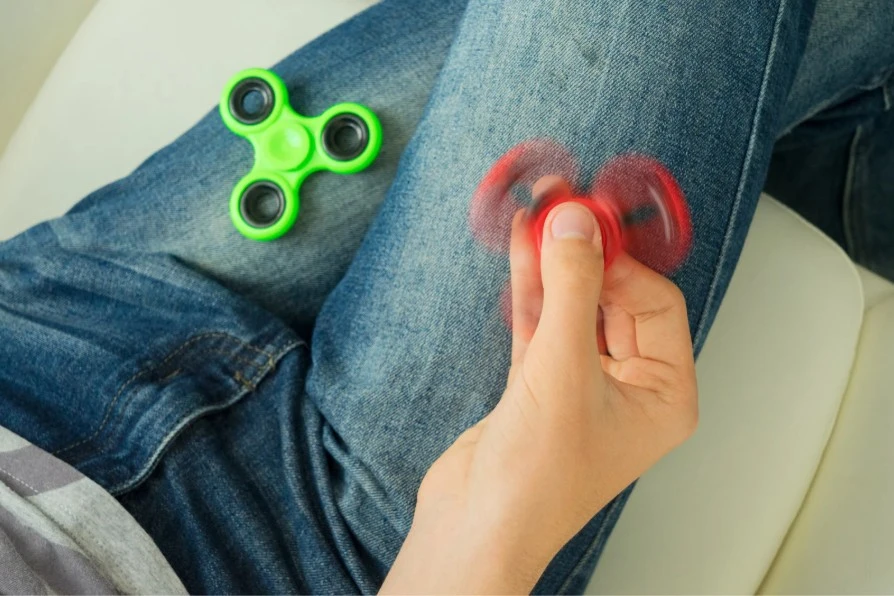 fidget spinner on lap of adhd human